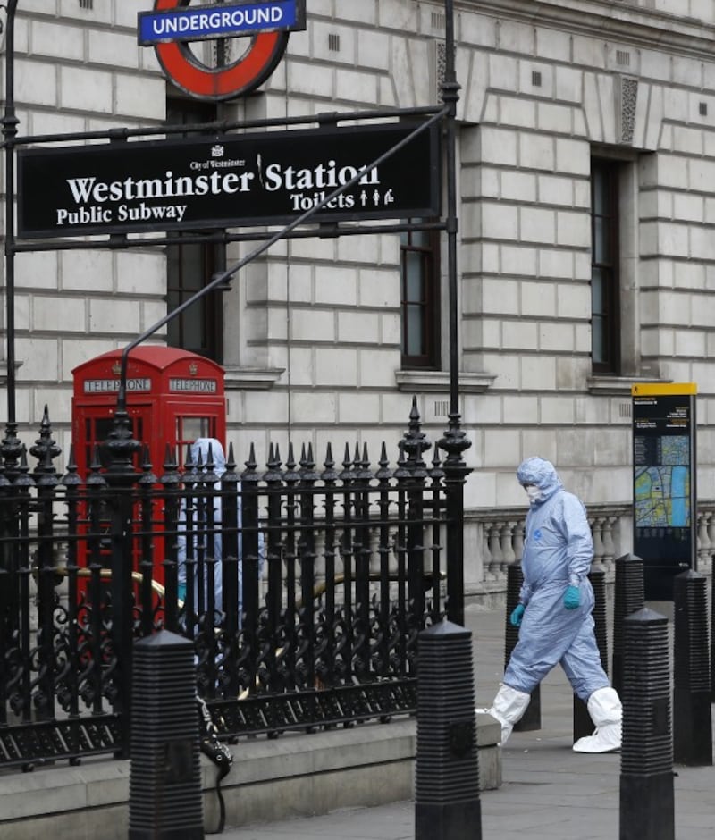 forensic officers walk by Westminster underground station (Kirsty Wigglesworth/AP)