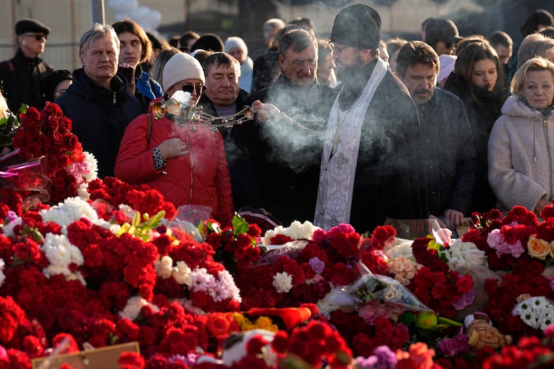 An Orthodox priest conducts a service at a makeshift memorial in front of the Crocus City Hall as officials called for harsh punishment for those behind the attack (AP Photo/Alexander Zemlyanichenko)