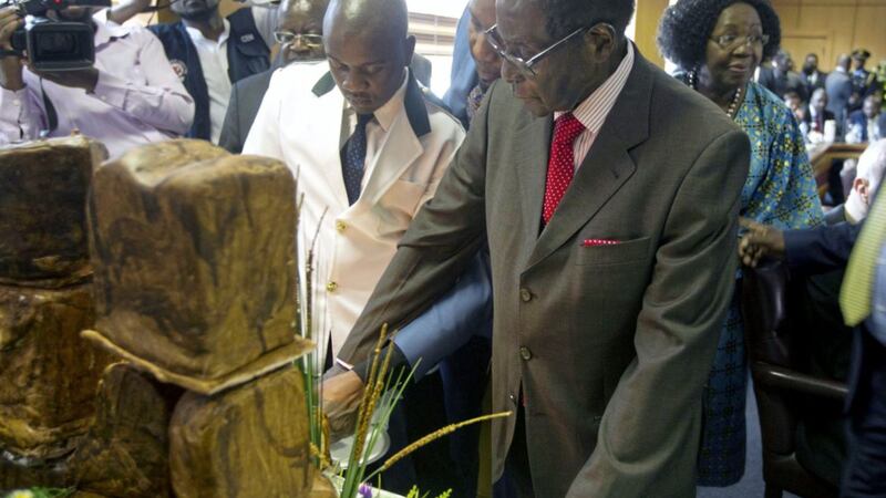Zimbabwe&#39;s president Robert Mugabe cuts his birthday cake as he marks his 93rd birthday at his offices in Harare on Tuesday. Picture by Tsvangirayi Mukwazhi, Associated Press 