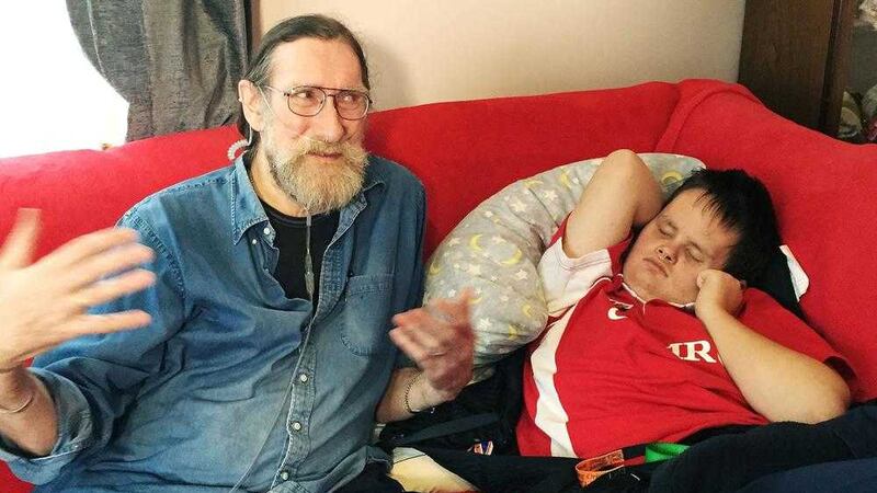 Paul Rutherford with his disabled grandson Warren at their home in Pembrokeshire, Wales. Picture by Benjamin Wright, PA