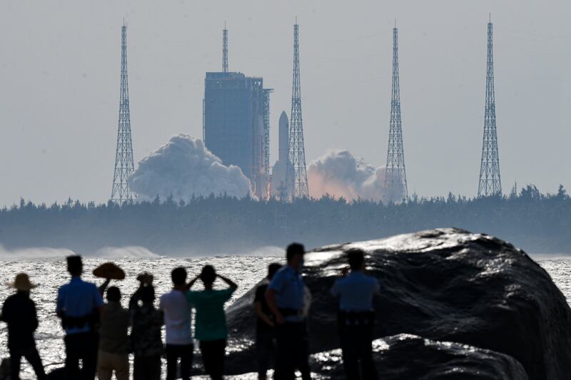 People watch the Long March-5B Y4 carrier rocket carrying the space lab module Mengtian (Yang Guanyu/Xinhua via AP)