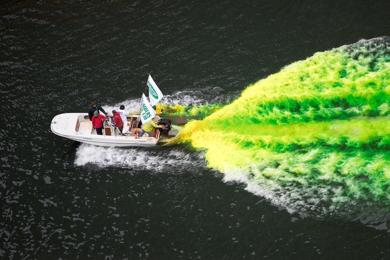A boat move through the water as the Chicago River is dyed green for St Patrick's Day
