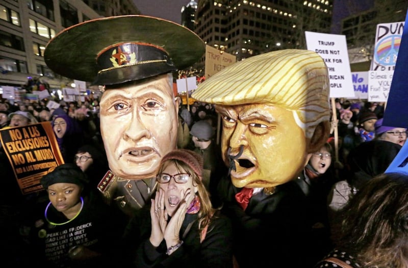 A woman in Seattle shouts out as she stands in front of giant puppet heads portraying Vladimir Putin and Donald Trump at rally to oppose Trump's executive order barring people from certain Muslim nations from entering the US. Picture by Elaine Thompson, AP
