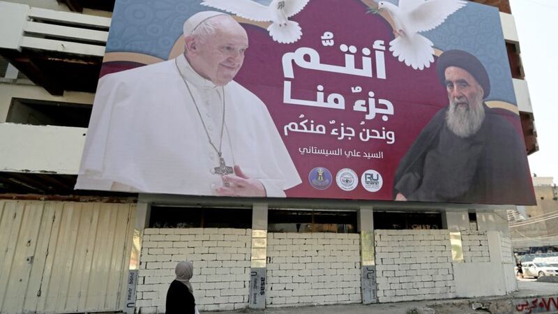 A billboard showing Pope Francis and Grand Ayatollah Ali al-Sistani, with Arabic that reads, &quot;You are a part of us and we are a part of you,&quot; hangs on a street in Baghdad, Iraq (AP/Photo/Khalid Mohammed). 