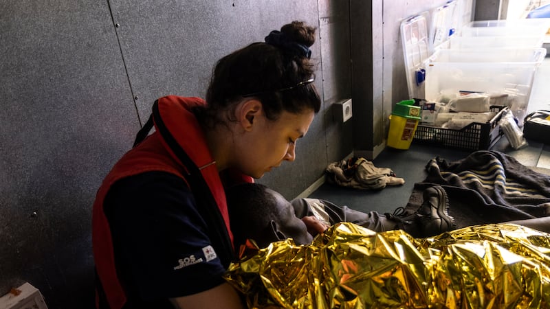 A rescue worker on the SOS Mediteranee’s humanitarian ship Ocean Viking attends to a rescued migrant (Johanna de Tessieres/SOS Mediteranee via AP)