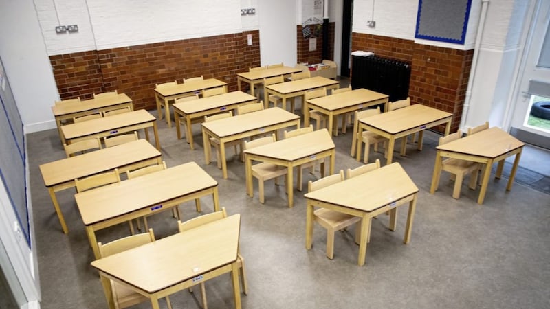Tables and chairs spaced for social distancing in a classroom 