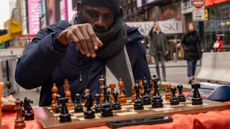 Tunde Onakoya, 29, a Nigerian chess champion and child education advocate, playing in Times Square in New York (Yuki Iwamura/AP)