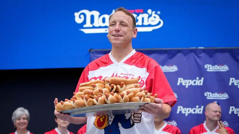 Competitive eater Joey Chestnut holds a plate of hotdogs during a weigh-in ceremony before the Nathan’s Famous July Fourth hot dog eating contest (John Minchillo/AP/PA)