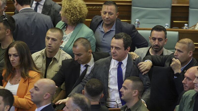 Bodyguards guard Kosovo Prime Minister Albin Kurti, centre, during a brawl in Kosovo’s parliament in Pristina (Ridvan Slivova/AP)