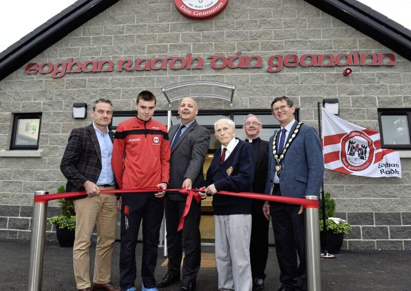 Cutting the ribbon to mark the official opening of the new Eoghan Ruadh hurling clubrooms, from left, Ulster GAA vice-president Ciaran McLaughlin, Conor MacGinty, John Ball of the Department for Communities, club founder member and president Teddy Devlin, Rev Dean Kevin Donaghy, and Mid Ulster council chair Martin Kearney. Picture courtesy of Michael Cullen, Dungannon Herald 