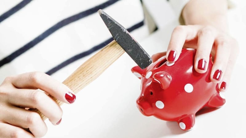 Red piggy bank and hammer held by woman 