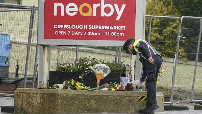 A member of An Garda lays flowers at the scene of an explosion at Applegreen service station in the village of Creeslough in Co Donegal on Sunday. Picture by PA 