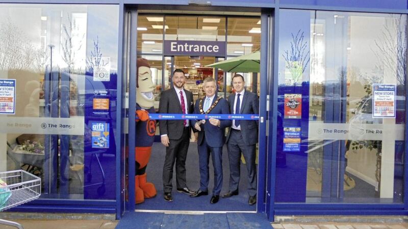Antrim &amp; Newtownabbey mayor Paul Michael cuts the ribbon at the new Range outlet at Glengormley, watched by store manager Donny McKindry and Range national sales manager Steve Groves                                 