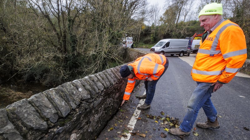 Workers clearing leaves from a section of the Quoile bridge after flooding (Liam McBurney/PA)