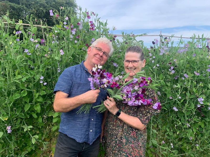 Couple standing in a field of flowers