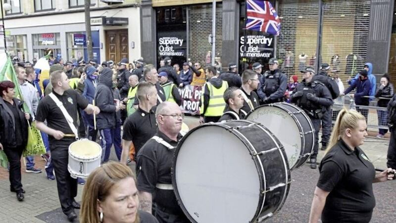 Republicans pass a loyalist protest during last year&#39;s parade through Belfast city centre  
