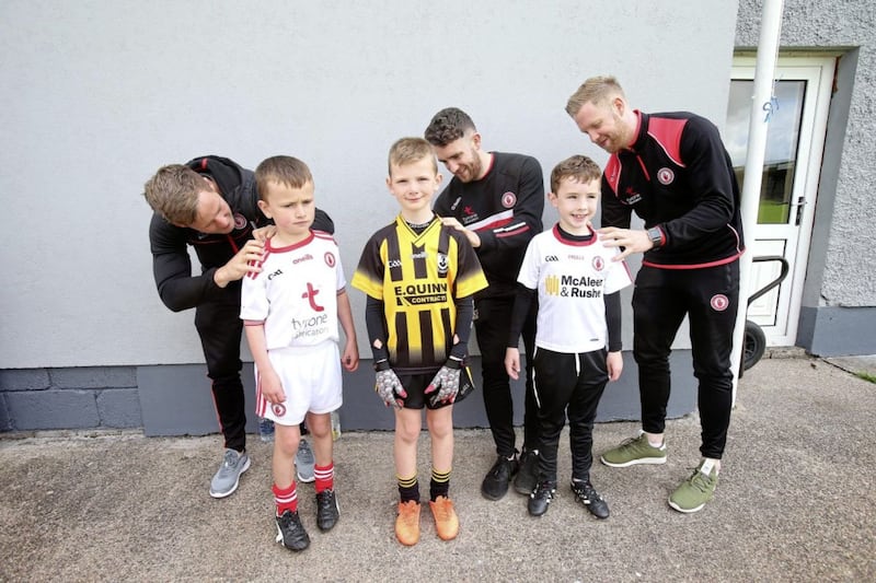 Kieran McGeary along with brothers Brendan and Frank Burns sign jerseys for young fans in Pomeroy during a Tyrone GAA summer camp. Picture by Mal McCann 