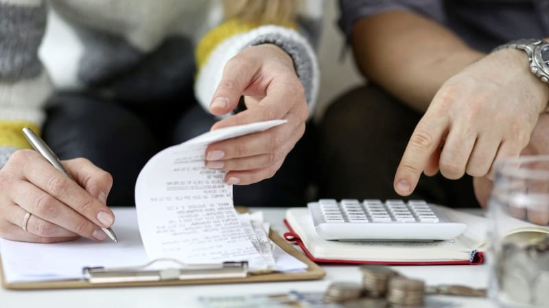 Close-up view of man and woman making account of family income. Writing down and calculating expenses. Attentive review of finance. Calculator on desk. Economy concept 