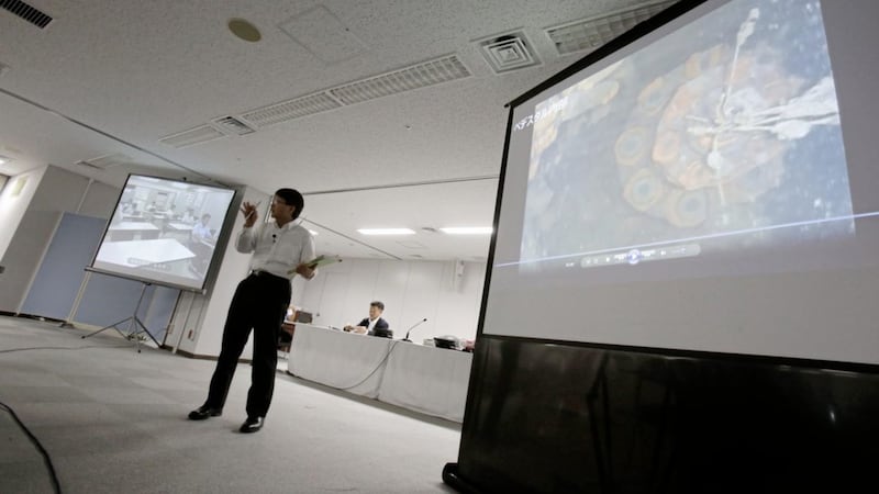 Tokyo Electric Power Co spokesman Takahiro Kimoto speaks during a press conference while showing video image taken by an underwater robot into Fukushima nuclear plant to search for melted fuel. Picture by Eugene Hoshiko, Associated Press 