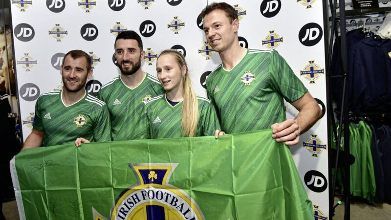 Northern Ireland's Niall McGinn, Conor McLaughlin, and Jonny Evans with a supporter at the launch of the new home jersey at Windsor Park.<br /> Photo Colm Lenaghan/Pacemaker Press
