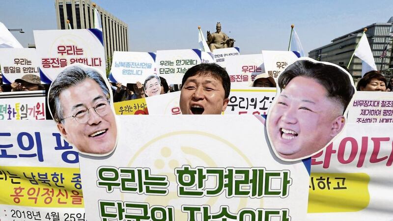 An activist with cutouts of South Korean President Moon Jae-in, left, and North Korean leader Kim Jong Un shouts during a rally welcoming the planned summit between South and North Korea in Seoul, South Korea. The signs read: &quot; We Are A Nation&quot; PICTURE: Ahn Young-joon/AP 