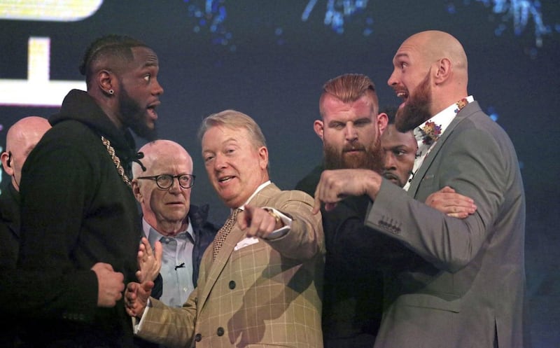 Deontay Wilder and Tyson Fury react as promoter Frank Warren (centre) keeps them apart during a press conference at BT Sport Studio, London yesterday 
