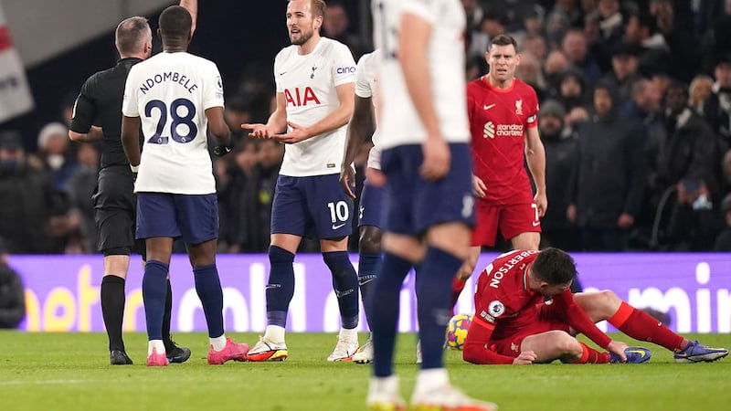 Referee Paul Tierney shows a yellow card to Tottenham Hotspur's Harry Kane for a foul on Liverpool's Andrew Robertson (right) during Sunday's Premier League match<br />Picture by PA