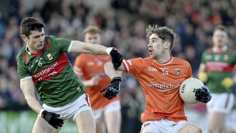 Mayo centre half-back Conor Loftus (left) challenges Armagh&#39;s Andrew Murnin. 