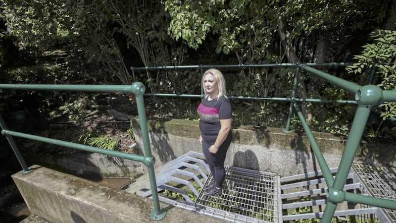 Karen Crooks at a storm drain behind her home on Northwood Street in north Belfast. Picture by Hugh Russell 