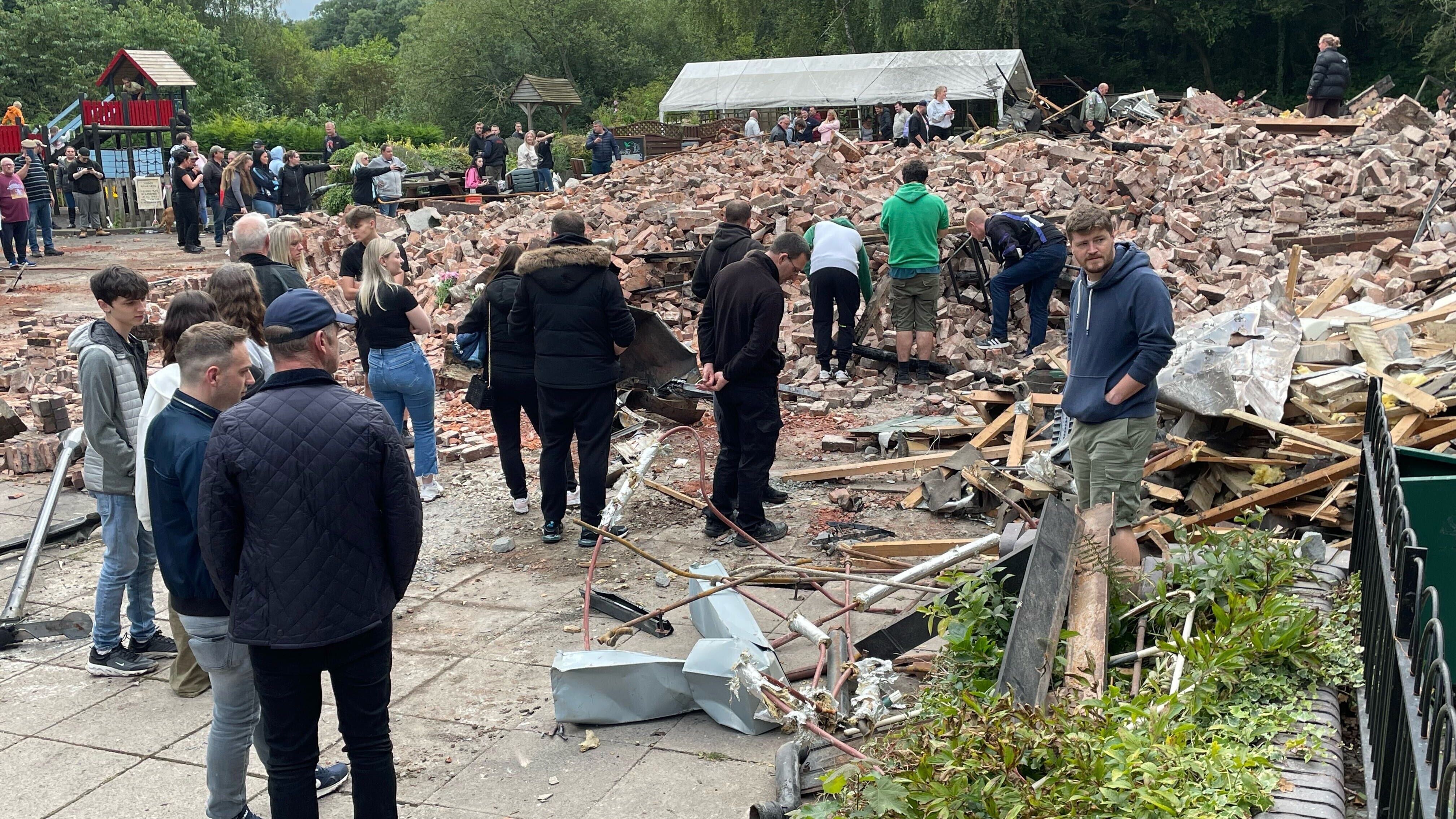 People inspect the rubble at The Crooked House pub (Matthew Cooper/PA)
