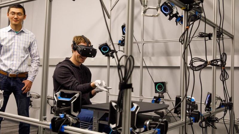 Mark Zuckerberg tries out concept VR gloves on visit to Oculus