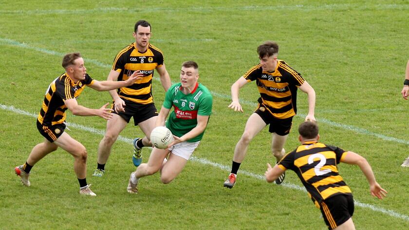 Gowna’s Ryan Brady lays the ball off having drawn the attention of Crosserlough’s Brandon Boylan, Conor Rehill, Oran Rehill and John Cooke respectively	 Picture: Adrian Donohoe