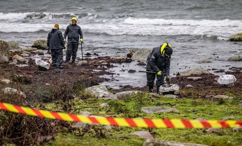 Personnel from the Coast Guard work on the clean-up after the oil leak from the grounded ferry Marco Polo on the coast of Horvik, southern Sweden on October 26
