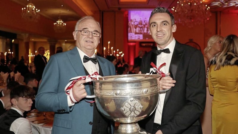 Pat McGuckin pictured with his son Kevin and the Sam Maguire Cup at a 2018 event to mark 25 years from Derry&#39;s All-Ireland win. Pat missed out on a Sigerson Cup medal with Queen&#39;s after being hit with a six-month ban for playing rugby - which expired the very day The Ban was abolished at Queen&#39;s in April 1971. 