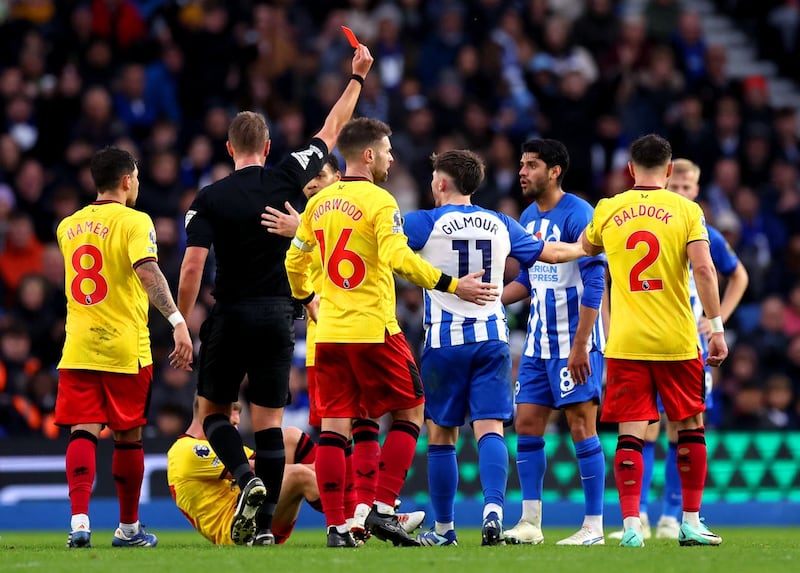 Brighton’s Mahmoud Dahoud, second right, is shown a red card