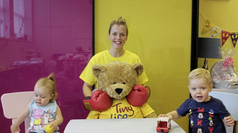Brenda Johannesson with her twins Eden and Odin square up to TinyLife Ted at the charity&rsquo;s east Belfast family centre 