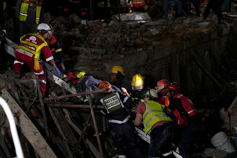 A survivor is brought to the surface at the scene of the building collapse (Nardus Engelbrecht/AP)