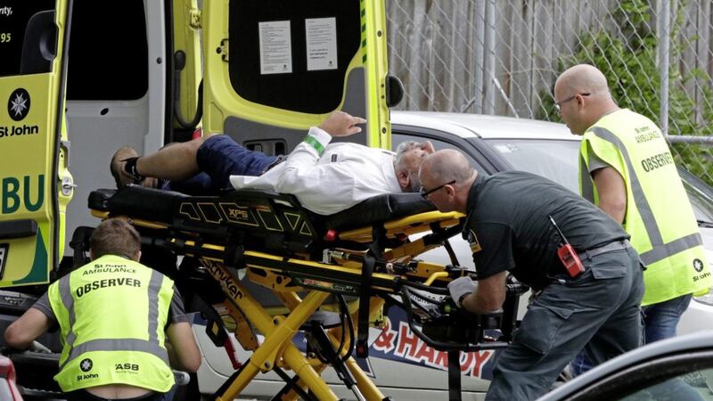 Ambulance staff outside a mosque in Christchurch with a man injured in Friday&#39;s attack.Picture by AP Photo/Mark Baker 