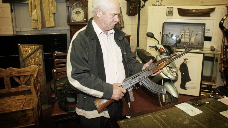 PUP member Ken Wilkinson pictured with memorabilia including an AK47 assault rifle which went under the hammer at a Belfast auction. pic McCann 