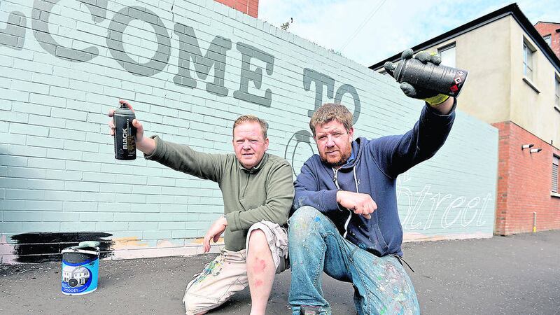 Artists Glenn Black, left, and Ken Maze get ready to start repainting murals on Lord Street in east Belfast