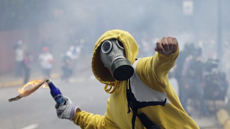 A demonstrator aims a fire bomb during an opposition May Day march in Caracas, Venezuela Picture: Ariana Cubillos/AP 