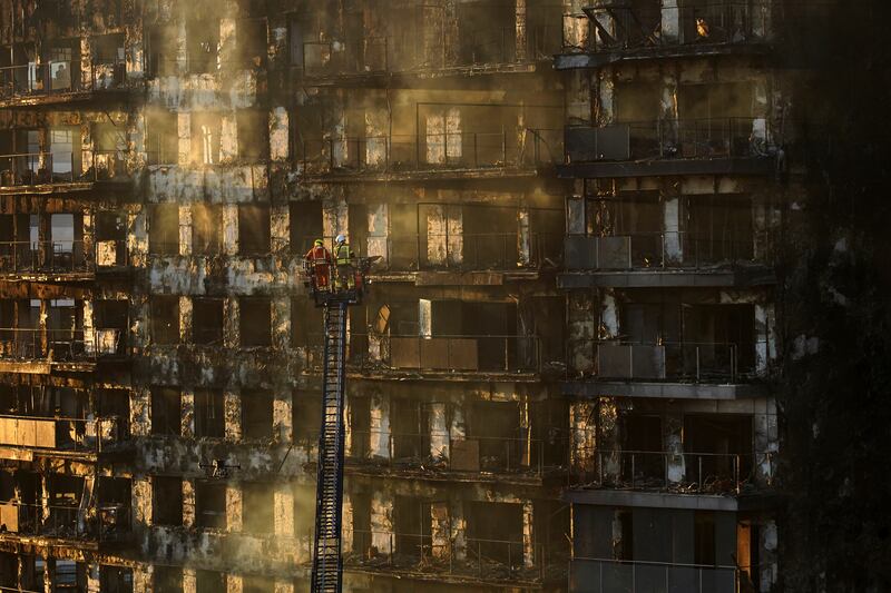 Firefighters work at a burned block building in Valencia, Spain (Alberto Saiz/AP)