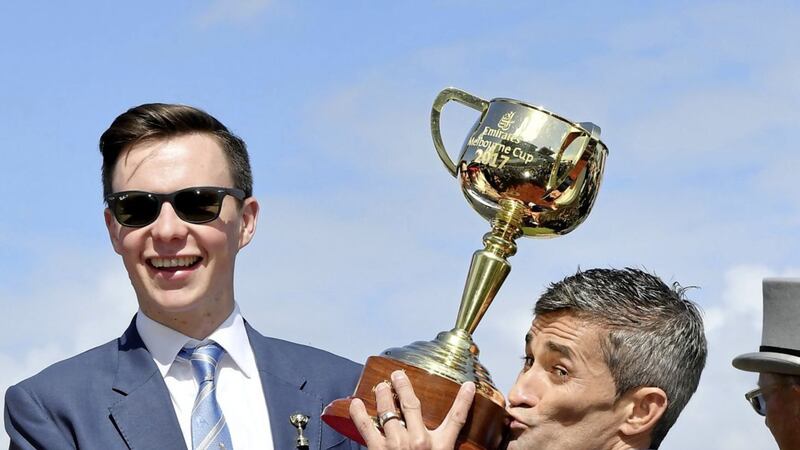 Jockey Corey Brown kisses the winning trophy in the mounting yard watched by trainer Joseph O&#39;Brien after Rekindling wins the Melbourne Cup at Flemington racecourse in Melbourne, Australia. Picture by AP Photo/Andy Brownbill 