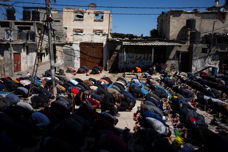 Palestinians perform the first Friday prayers of the Muslim holy month of Ramadan near the ruins of a destroyed mosque in Rafah (Fatima Shbair/AP)