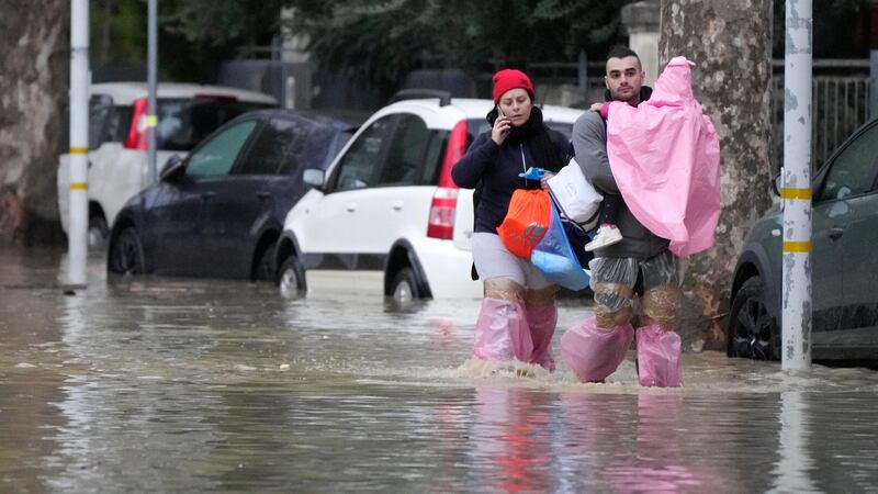 People make their way on a flooded street in Campi di Bisenzio, in the central Italian Tuscany region (AP Photo/Gregorio Borgia)
