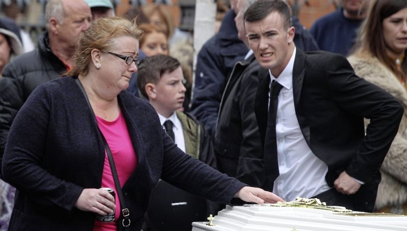 Carol Corr says goodbye to her daughter Joleen as she touches her white coffin outside St Paul&#39;s Church in west Belfast. Picture Matt Bohill 