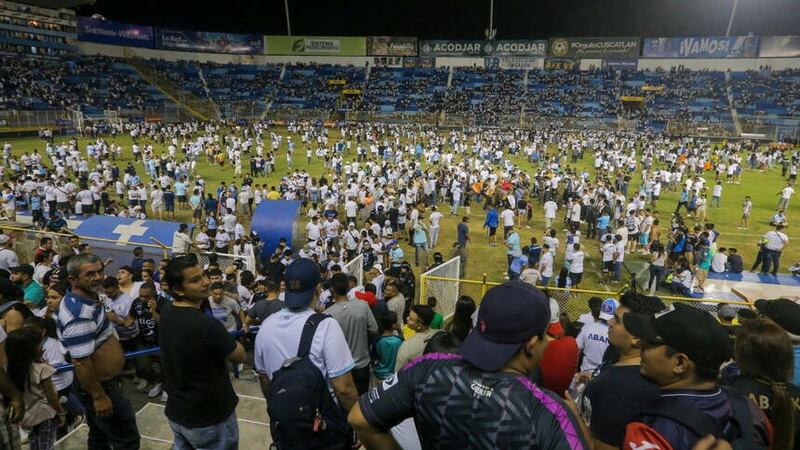 Fans are forced on to the pitch during a crush at the Monumental Stadium in Cuscatlan, El Salvador (Milton Flores/AP)
