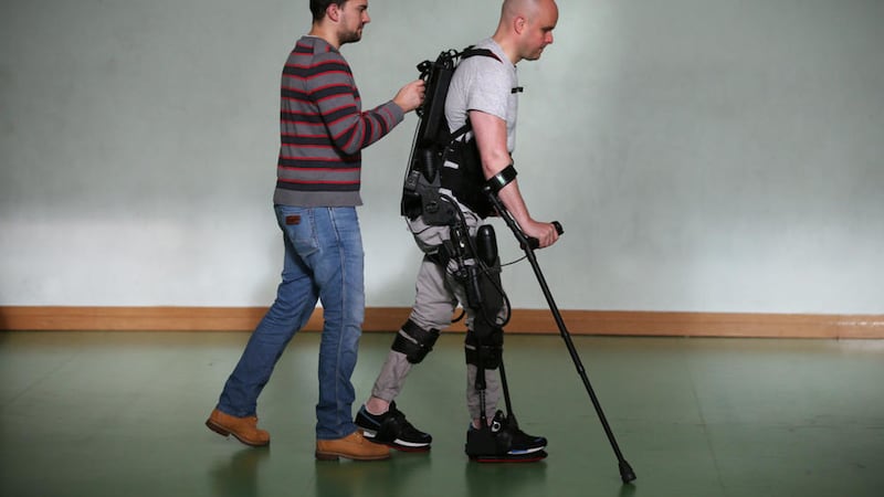 Mark Pollock is helped by his assistant as he walks using the Ekso Bionics robotic exoskeleton at Trinity College Dublin Picture: Peter Macdiarmid/Mark Pollock Trust 
