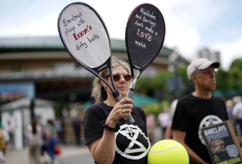 Rachie Ross holding up signs outside of the Wimbledon gates