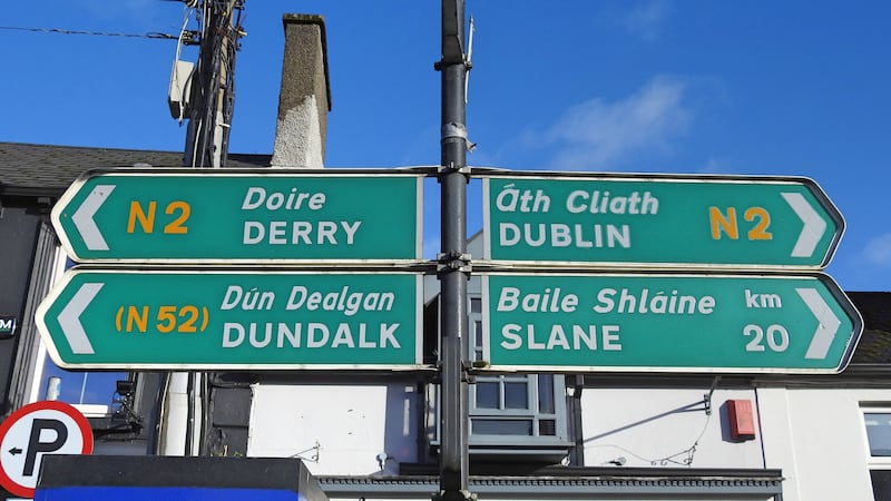 Road signs for Derry, Dundalk, Dublin and Slane in the English language, each translated directly into the Irish language words, located in Ardee town, County Louth, Ireland.
